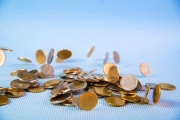 Falling coins money on blue background, business wealth concept.