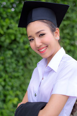 Graduate woman students wearing graduation hat and gown, congratulations for end of study