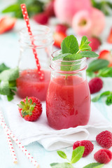 Healthy antioxidant red smoothie with apple juice, fresh strawberries, raspberries and mint