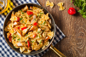 Pasta farfalle with chicken and paprika, in carbonara sauce.