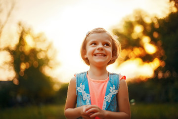 Five years old caucasian child girl with fair hair looking away and smiling outdoor at sunset. happy carefree childhood © ZaStock