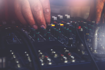 DJ's hand on control panel