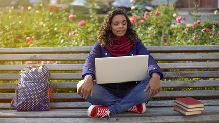Biracial student in good mood sitting on bench, dreaming about bright future - Powered by Adobe