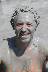 Mud treatment at the Dalyan, Turkey. Portrait happy man who takes a mud bath