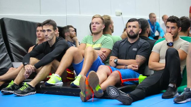 Young men listening a trainer on the training in the gym