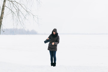 Fototapeta na wymiar Woman winter clothing standing snowy landscape pours drinks coffee
