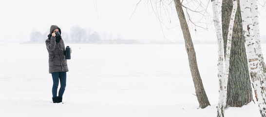 Woman winter clothing standing snowy landscape drinks coffee