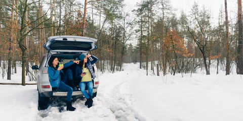 Two young women traveler traveling by car winter