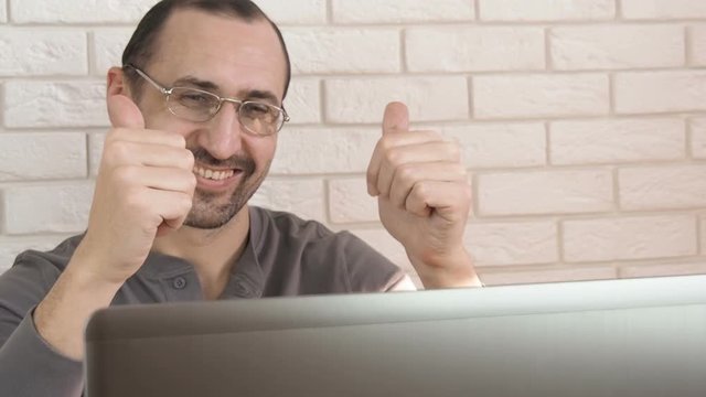 A cheerful man at the computer.