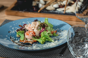 delicious salmon salad with shrimp and egg in a restaurant. small portion