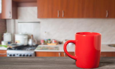 red cup on a wooden surface on a kitchen background