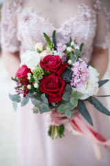 Wedding bouquet with roses in brides hands