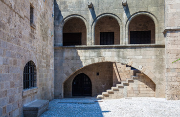 Fototapeta na wymiar Archs and stone staircase in the house on the Argyrokastrou square, Rhodes island, Greece