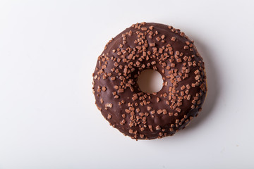 Glazed chocolate donut with sweet chocolate sprinkles on white background