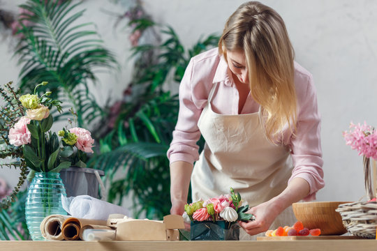 Photo of blonde florist making bouquet of marshmallows, flowers
