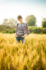Beautiful asian woman pose in gold barley wheat field at sunset time