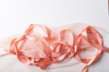 Shiny pink satin ribbon with transparent fabric on white background