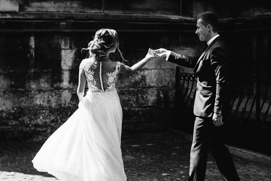 the newlyweds dance, the bride is standing back to the camera lens on black and white photography