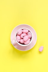 Pink easter eggs in pink coffee cup. Easter holiday background