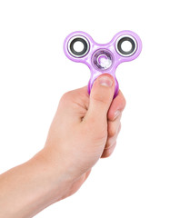 Child hand holding popular fidget spinner toy, isolated on white background. Kid playing with a purple Spinner. 