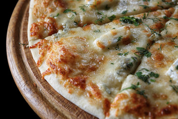 Pizza four cheeses on a wooden board