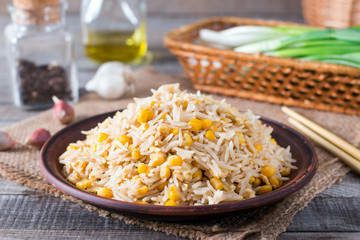 Asian fried rice with eggs and corn on the plate on wooden background