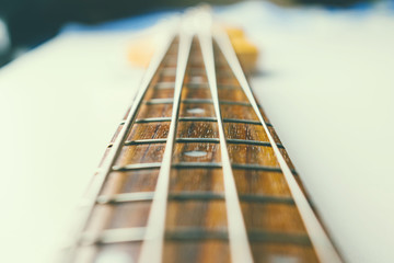 Frets on bass guitar. Close up. Vintage old retro bass in studio. Warm soft style