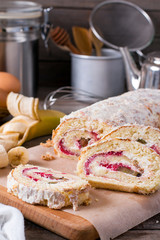 Homemade sweet biscuit roll with cream on wooden background
