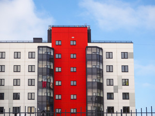 Modern beautiful new buildings. Colored wall on the background of blue sky.
