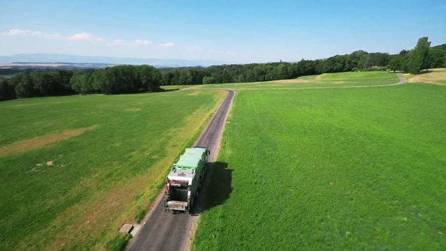 Truck in the countryside - aerial shot. Waste truck, collecting trash