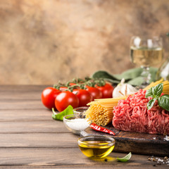 Ingredients for spaghetti Bolognaise or Bolognese with savory minced beef and tomato, basil and spices. Italian healthy food concept with copy space.