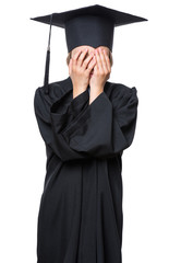 Sad crying disappointed graduate little girl student in black graduation gown with hat - isolated on white. Negative human emotion facial expression. Child back to school, educational concept.