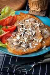 Crispy fried homemade potato pancakes with mushroom sauce.