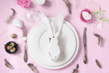 Easter romantic dinner. Elegance table setting spring pink flowers on pink linen tablecloth. Top view.