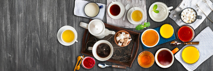 Different cold and hot drinks on wooden table. Tea, milk, juice,coffee, smoothie, water, pot, tray and tissue. Concepts of healthy traditional tasty drinks.