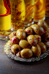 Spiced green olives and bottles with olive oil .