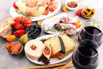 Italian antipasti wine snacks set. Cheese variety, Mediterranean olives, pickles, Prosciutto di Parma with melon, salami.