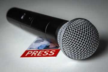Black microphone with journalistic ID on the table