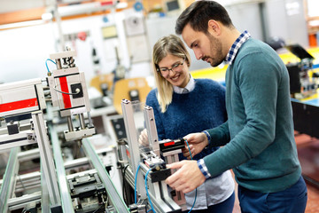 Young attractive students of mechatronics working on project