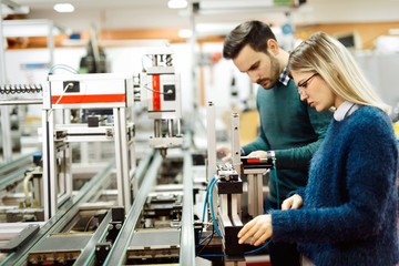 Young attractive students of mechatronics working on project