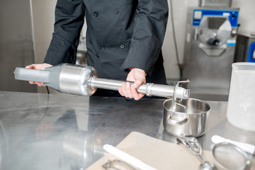 Chef cook taking professional blender for ice cream mixing in the kitchen