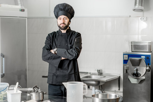 Portrait of a chef cook standing in the professional kitchen during the process of ice cream making