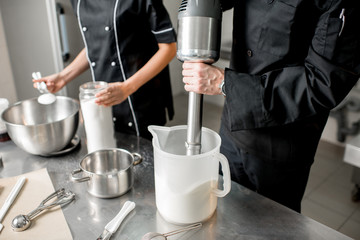 Chefs mixing ingredients for ice cream production in the professional kitchen. Close-up view wuth...