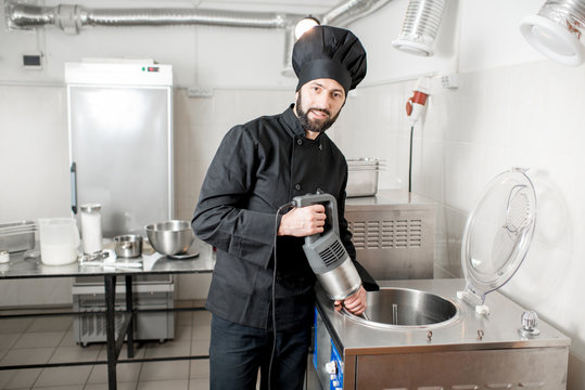 Chef cook mixing milk in pasteurization machine prepairing basis for ice cream production