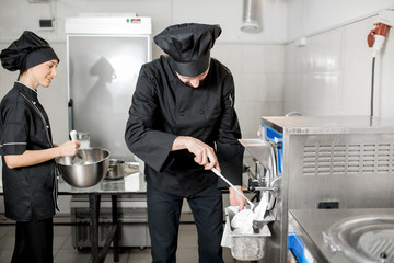 Chef getting white ice cream from the ice cream maker machine in the small manufacturing