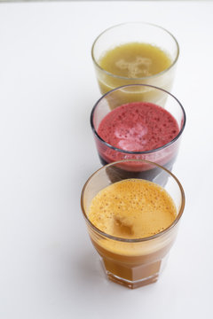 carrot, apple and beetroot juice on a white background top view.
