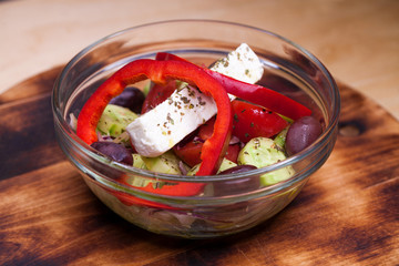 Greek salad is served with large pieces of cheese and vegetables