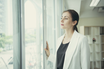 young businesswoman thinking idea and looking the window at office.