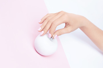 Woman Hand With Pink Pastel Nails And Apple