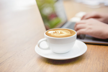 Coffee cup of latte art on wooden table